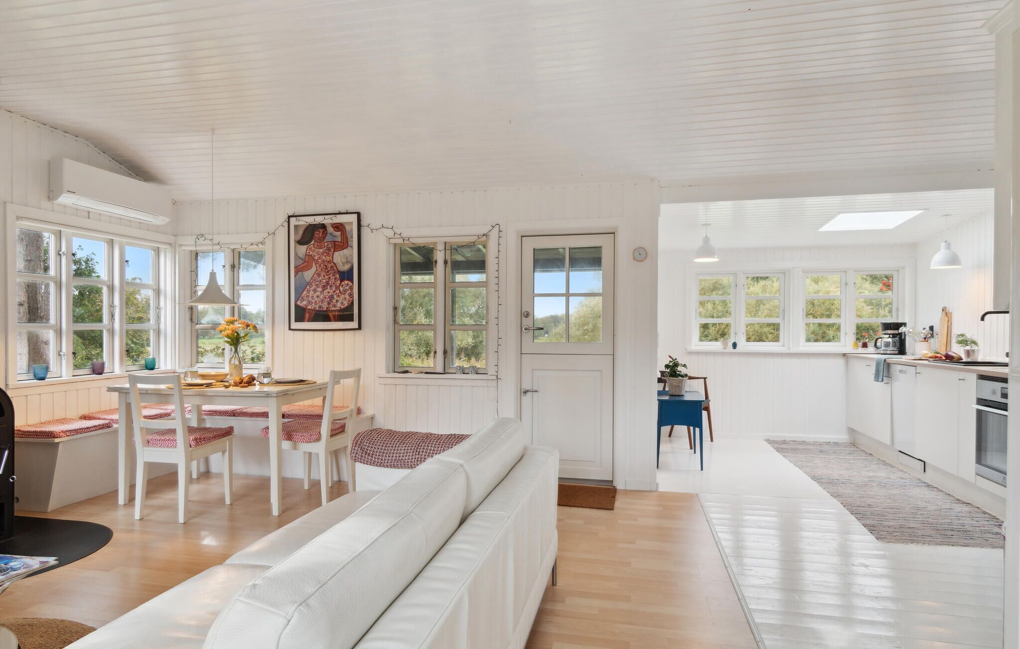 A bright, open-plan living space with a dining area, kitchen, and seating area.