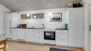 A modern kitchen with white cabinets, a black oven, and a window with a view of trees. - Pet friendly home in Gistrup with WiFi (Gistrup)