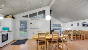 A spacious kitchen with modern appliances, a dining area with wooden furniture, and large windows allowing natural light. - Pet friendly home in Gistrup with WiFi (Gistrup)