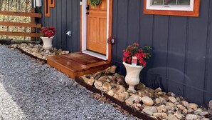 A cabin with a wooden door, a front porch, and a mailbox. - City Overlook cabin  (Pigeon Forge)