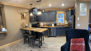 A modern kitchen with dark cabinets, a central island, and pendant lighting. - City Overlook cabin  (Pigeon Forge)