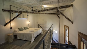 A bedroom with a bed, a wooden ladder, a small stool, and a staircase leading to an upper level. - YOUR PLACE IN THE HEART OF BUENOS AIRES (CABA)