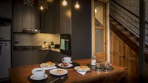 A modern kitchen with a wooden countertop, a coffee station, and a view of a wooden staircase. - YOUR PLACE IN THE HEART OF BUENOS AIRES (CABA)