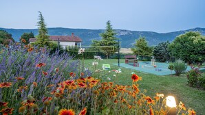 A garden with a variety of flowers, a tennis court, and a house with a red roof. - Awesome home in Krsan with private swimming pool, can be inside or outside (Krsan)