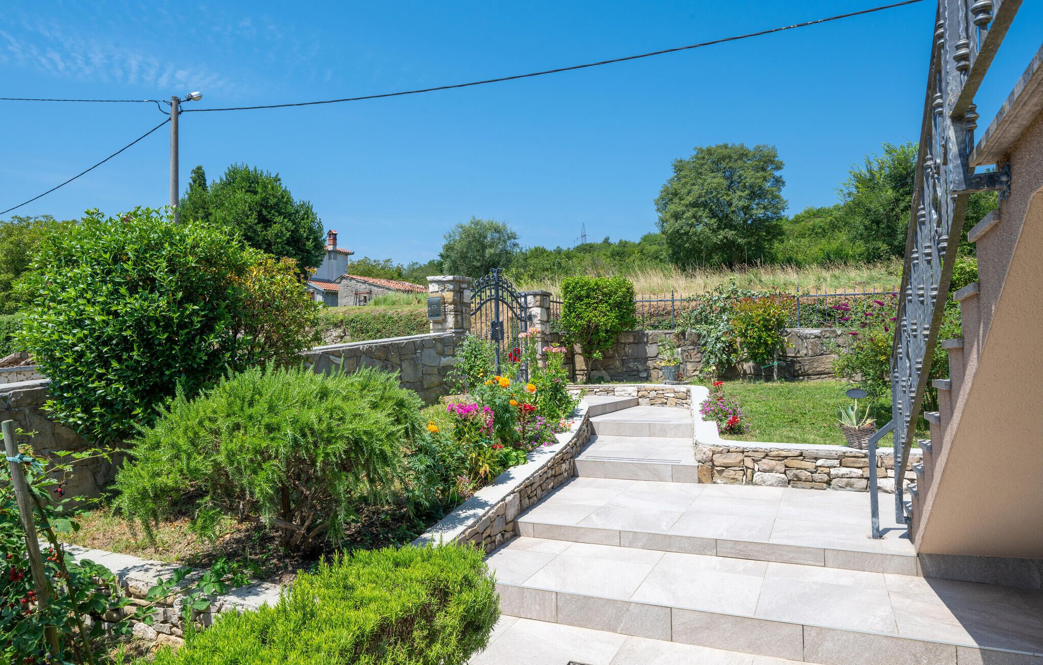 A stone staircase leading to a house with a garden.