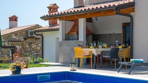 A poolside area with a covered patio, outdoor seating, and a stone building in the background. - Awesome home in Krsan with private swimming pool, can be inside or outside (Krsan)