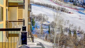 A hotel with a balcony overlooking a snowy mountain landscape.
