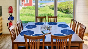 A dining table with a view of a lake and a red building in the background.