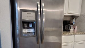 A stainless steel refrigerator with a water dispenser and a coffee maker on the countertop. - Close to downtown 14mint Airport 15 minute and south (Austin)