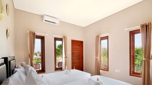 A hotel room with two beds, a TV, and a balcony with curtains. - Askara Villa Uluwatu (Ungasan)