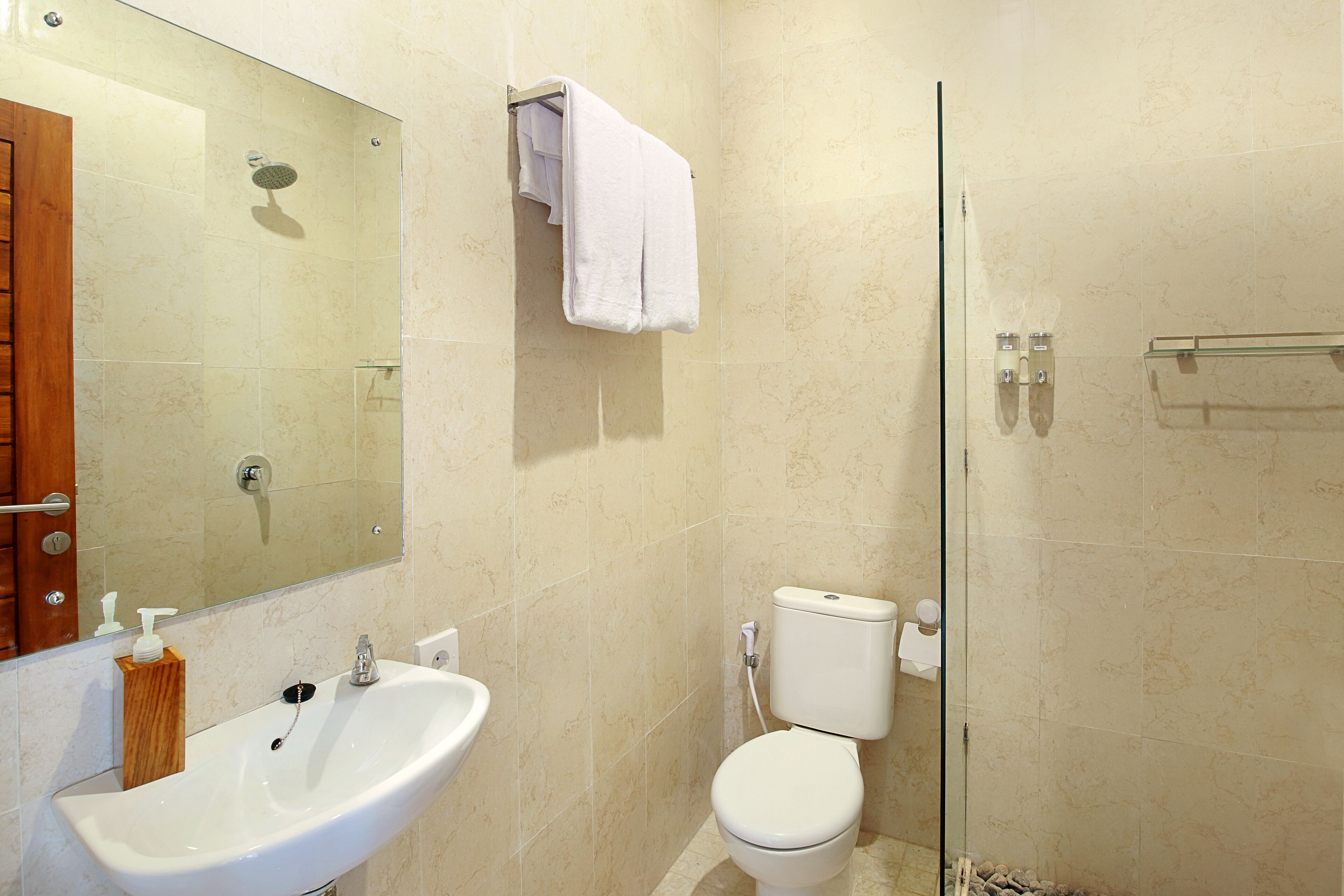 A bathroom with a sink, toilet, and glass shower enclosure.