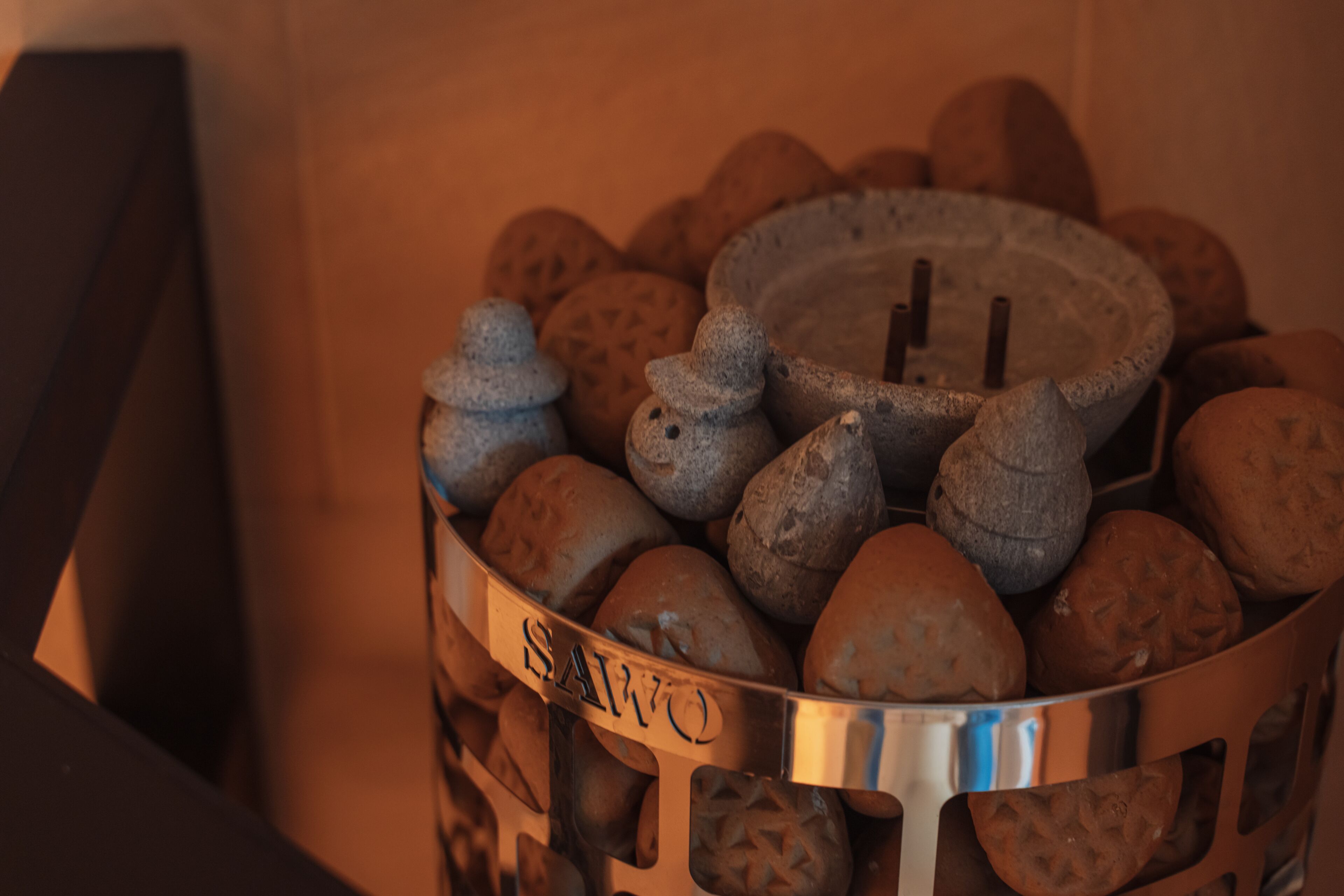 Ein Metallkorb, gefüllt mit unterschiedlich geformten Brotlaugen, einige mit einer Beschriftung mit dem Schriftzug 'SAWO'.