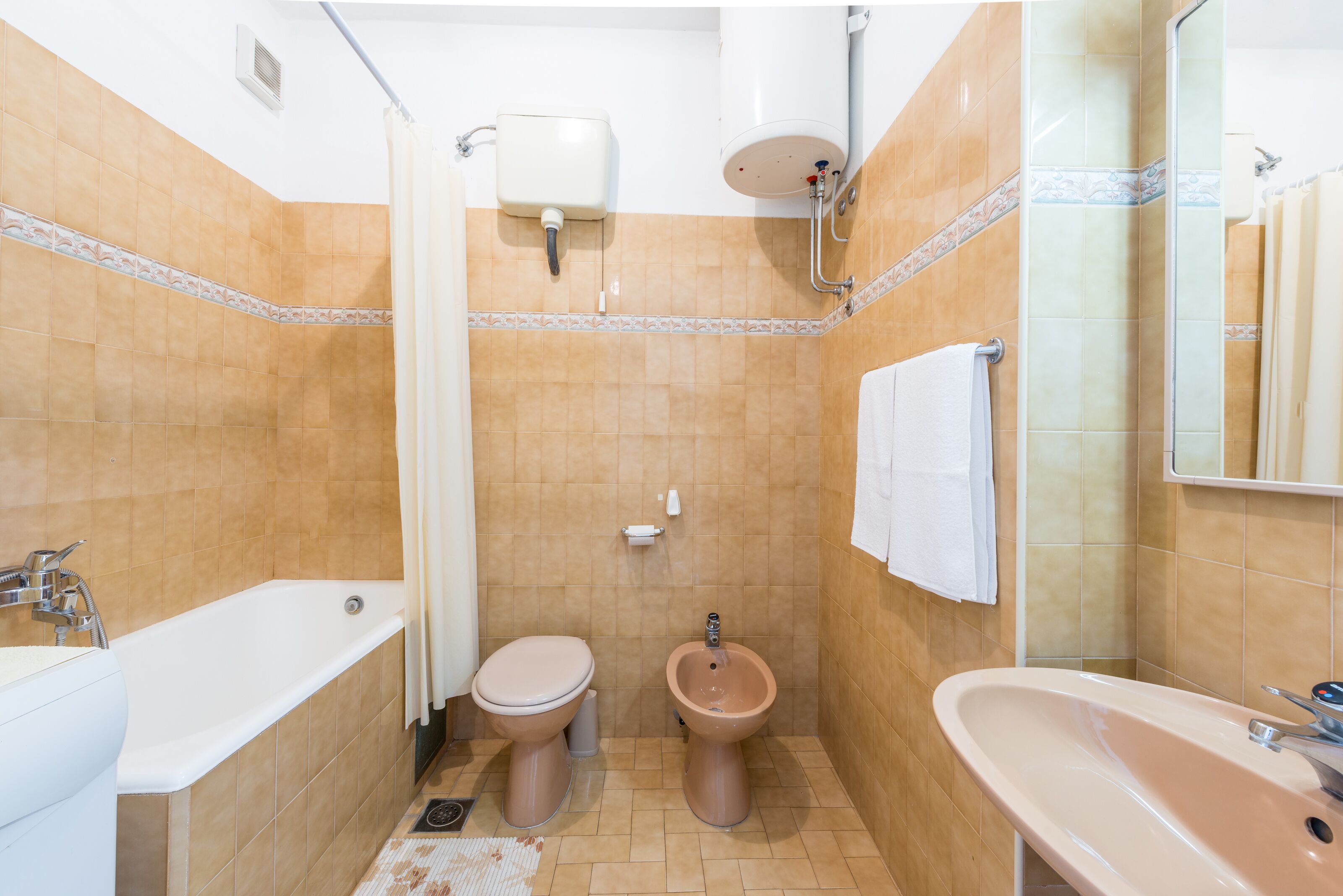 A bathroom with a bathtub, toilet, bidet, and sink.