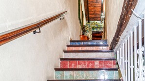 A staircase with a wooden handrail, colorful tiled steps, and a potted plant at the top. - Lovely home in Arenas del Rey with WiFi (Arenas del Rey)