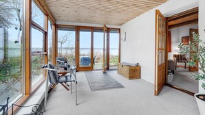 A spacious room with large windows, a wooden ceiling, and a view of the outdoors. - Lovely home in Mariager with WiFi (Mariager)