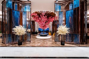 A lobby with a central floral arrangement, a curved ceiling, and a marble floor. - Calyptus Kirman Premium - Ultra All Inclusive (Manavgat)