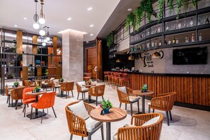 A modern bar area with multiple seating options, a bar counter, and a variety of bottles displayed on shelves. - Calyptus Kirman Premium - Ultra All Inclusive (Manavgat)