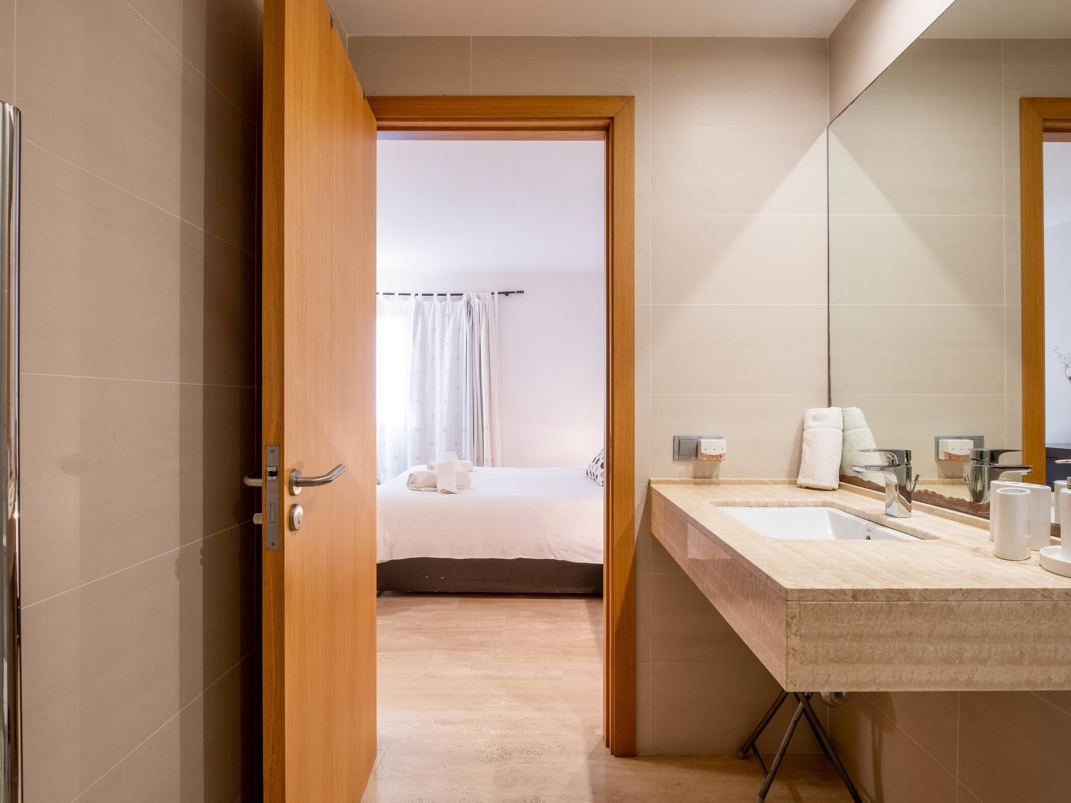 Ein modernes Badezimmer mit großem Spiegel, zwei Waschbecken und einer Duschkabine.