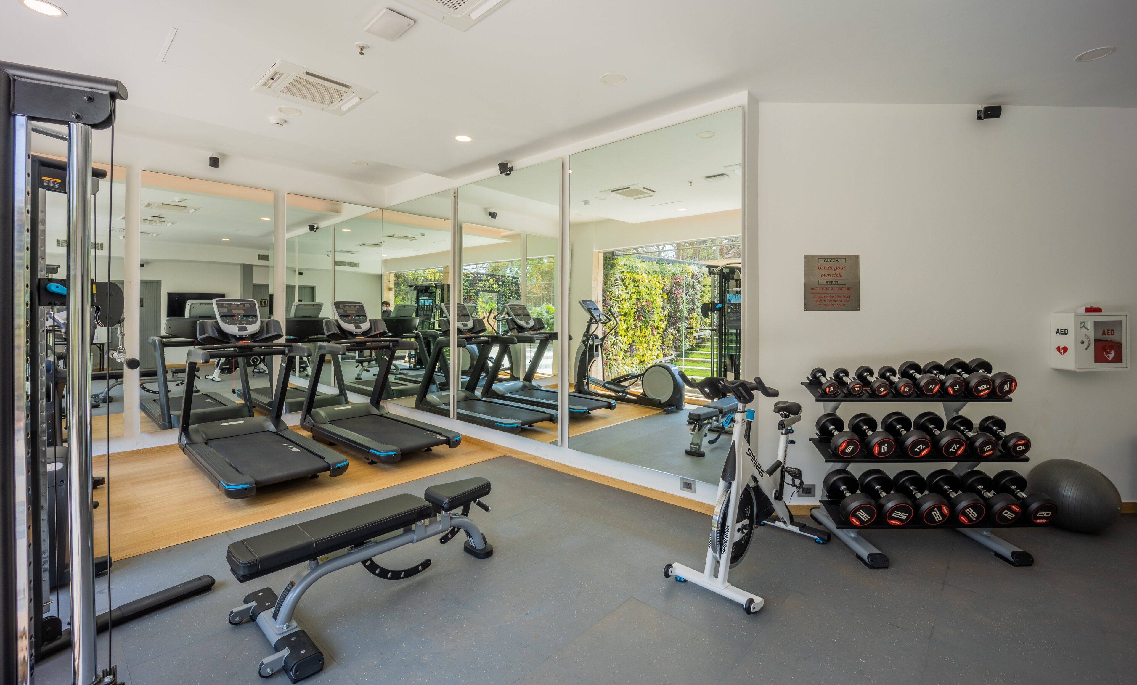 A modern gym with treadmills, weight machines, and a bench press area.