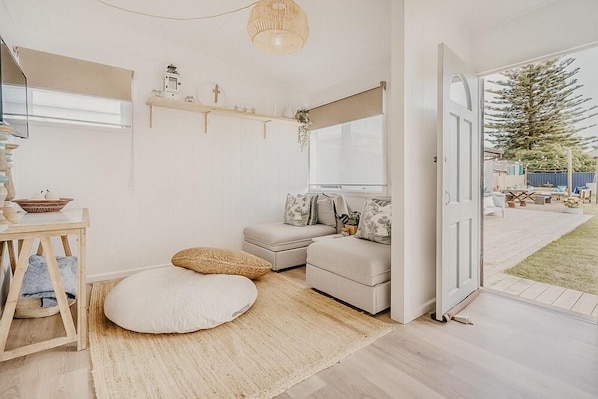Een gezellige kamer met een bank, een klein tafeltje, een hanglamp en uitzicht op de omgeving.