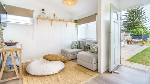 Una habitación acogedora con un sofá, una mesita y un ventanal amplio.