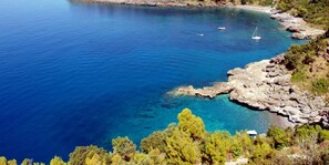 A coastal landscape with a clear view of a bay, rocky shoreline, and a small settlement with buildings labeled 'casa', 'spia', and 'pace'.