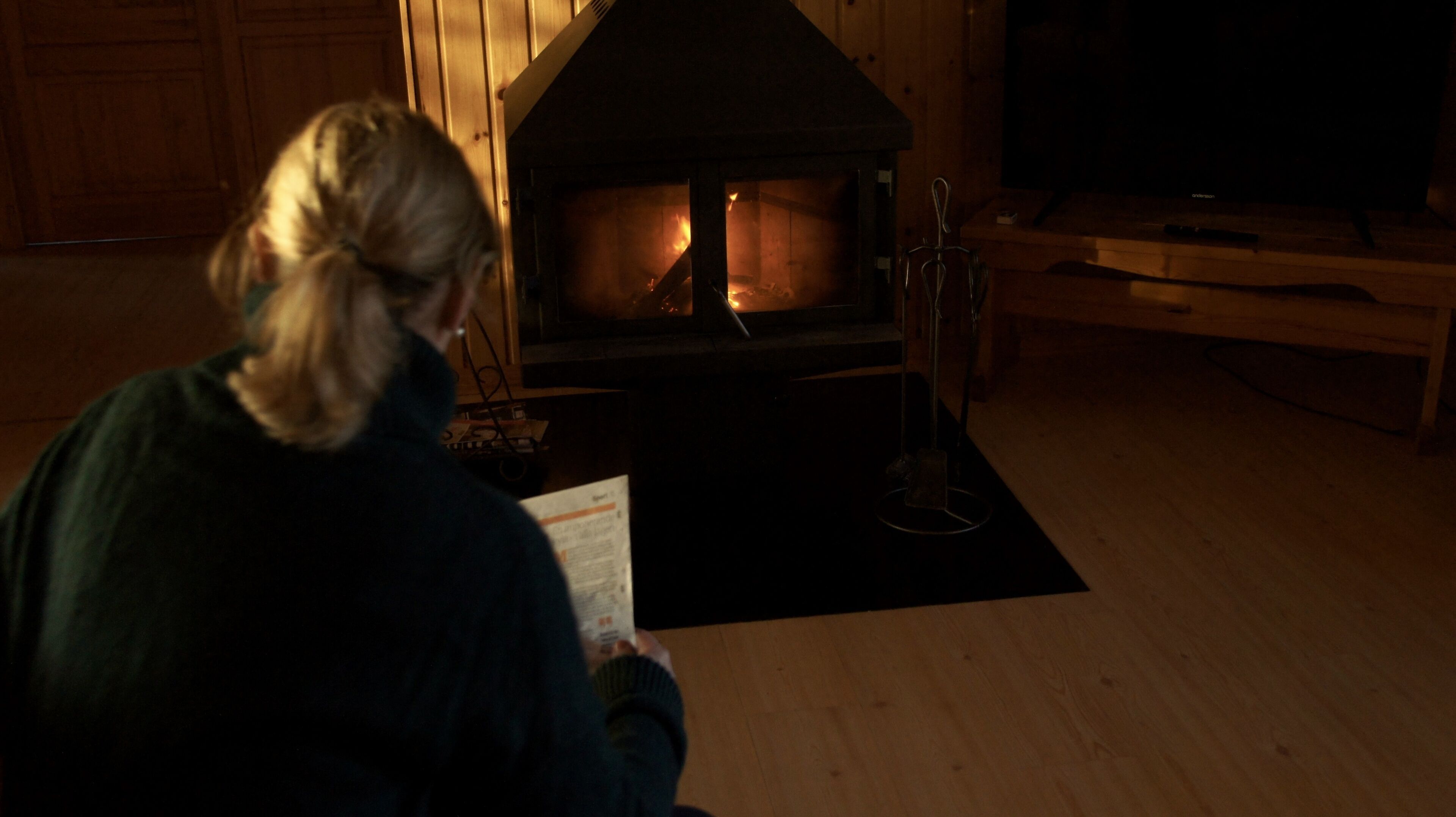 Iemand leest een boek in een kamer met een open haard.