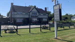 Perinteinen, Tudor-tyylinen pub nimeltä The George Inn, jonka kyltissä mainostetaan majoitusta ja aamiaista, pubiruokia, vapaasti tarjolla olevia juomia, laadukkaita oluita ja ilmaista Wi-Fi-yhteyttä.