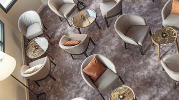 A room with multiple seating areas, including chairs and tables, arranged in a circular pattern.