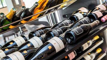 A collection of wine bottles on shelves, likely in a wine shop or restaurant.