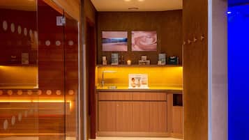 Welcome to our reception area, featuring a digital screen, framed artwork, and a cozy seating area with a candle.