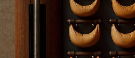 A room with a wooden column, a wall-mounted television, and a series of leather straps.