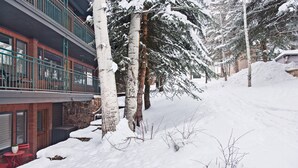 A snow-covered outdoor area with a building featuring a balcony and a brick facade. - Special VRBO Rates! - Steps to Gondola! Cozy Aspen Stay (Aspen)