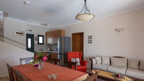 Un amplio salón con una mesa de comedor, un sofá y una cocina al fondo.