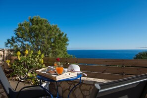 A table with breakfast items and a view of the ocean. - Potamitis Windmills & Apartments (Zakynthos)