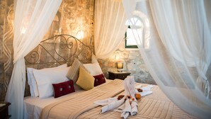 A bed with white linens, a red pillow, and a white towel laid out. - Potamitis Windmills & Apartments (Zakynthos)