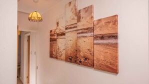 A hallway with a wall-mounted artwork depicting a beach scene. - *Relocation, Business and Contractor Long Stays! (Oxford)