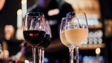 Two glasses of wine, one red and one white, on a bar counter.