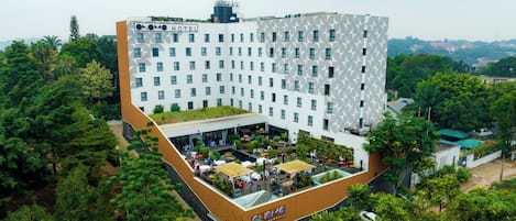Un hotel con una fachada geométrica única, un jardín en la azotea y una zona de estar al aire libre.