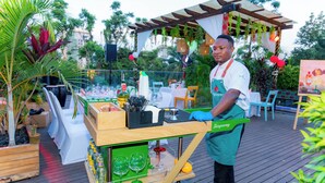 Een bar met een houten toonbank, glazen, flessen en een menukaartstandaard.
