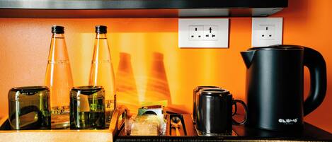 A kitchen counter with various items including bottles, a kettle, and a coffee maker.