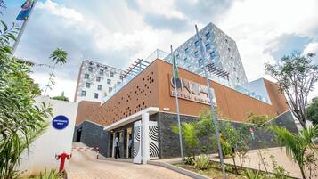 A hotel entrance with a modern design, including a patterned facade and a clear sign indicating "Entrance Only".