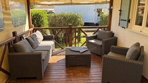 Ein überdachter Außenbereich mit Korbmöbeln und einer Holzterrasse.