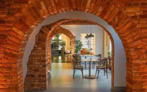 Un comedor con un arco de ladrillo, una mesa redonda y sillas.