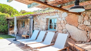 A stone building with a wooden deck, outdoor seating, and a pergola. - Casa Sarralonga Di Porto-Vecchio (Porto-Vecchio)