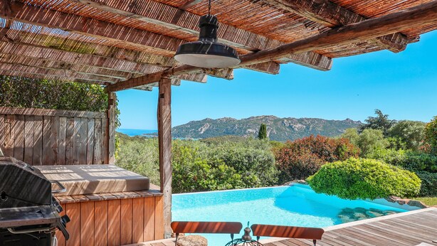 A wooden deck with a barbecue, a pool, and a view of mountains. - Casa Sarralonga Di Porto-Vecchio (Porto-Vecchio)