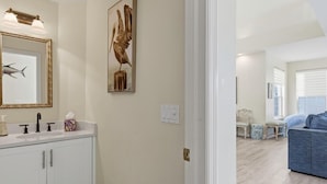 A bathroom with a white vanity, a framed mirror, and a wall-mounted light fixture. - Waterfront 5BR retreat with heated pool in Marco Island (Marco Island)