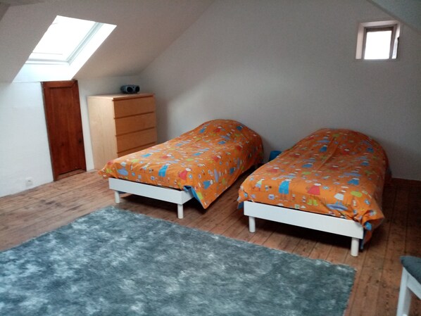 A bedroom with two beds, a wooden dresser, a skylight, and a small window. - La Partite Maison du Portrieux (Saint-Quay-Portrieux)