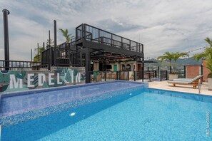 Una piscina al aire libre, tumbonas