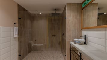 Een moderne badkamer met douche, toilet en wastafel.